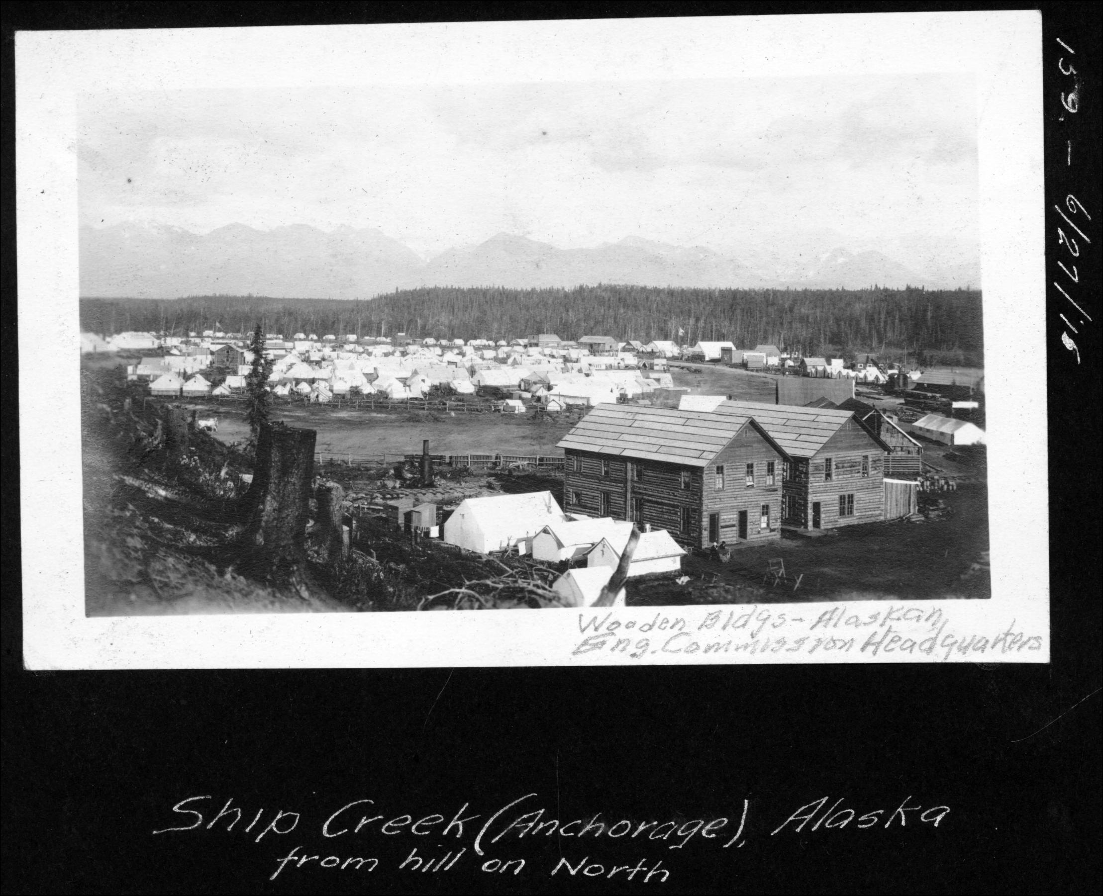 Aerial view of Ship Creek tent city from the hill on the north side, showing wooden Alaska Engineering Commission headquarters, June 1915